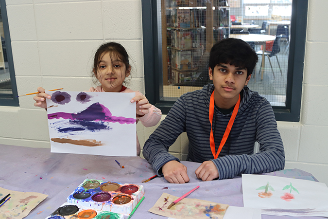 Volunteer and child work on art project